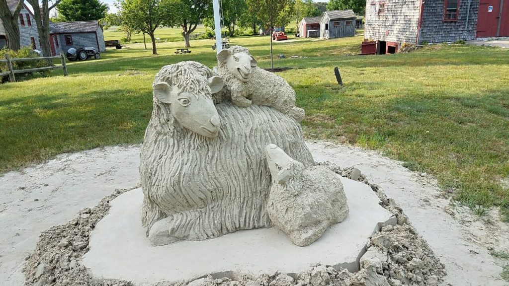 sand sculpture of a sheep with two lambs